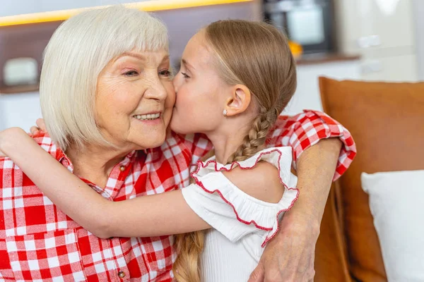 Kärleksfull ung dam kysser sin glada mormor — Stockfoto