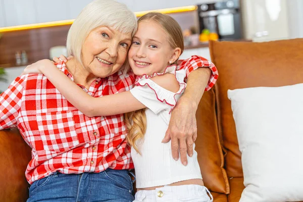 Gyönyörű lány copfokkal öleli a nagymamáját — Stock Fotó
