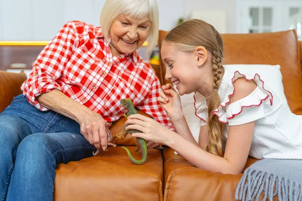 Mulher alegre envelhecida brincando com uma menina — Fotografia de Stock