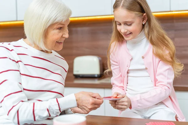 Schattig meisje met kaarten in haar handen — Stockfoto