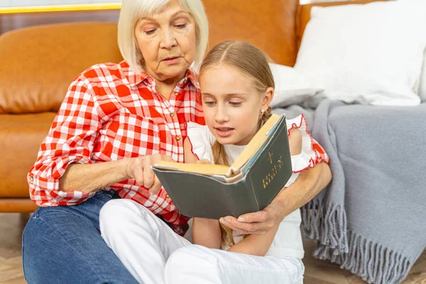 Enfocado chica bastante joven leyendo la Biblia —  Fotos de Stock