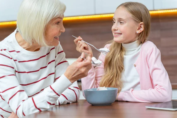 Kleindochter en oma eten samen dessert. — Stockfoto