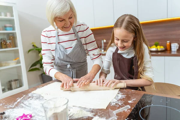 Mujer mayor y su nieta haciendo la masa — Foto de Stock