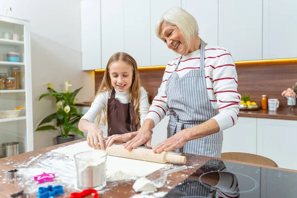 Leende äldre kvinna rullar ut bakverk — Stockfoto