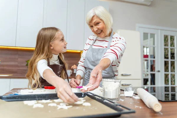 Жіночі пекарі кладуть печиво на лист для випічки — стокове фото
