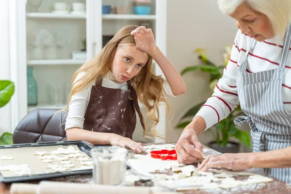 Chica bonita ayudando a su abuela hornear galletas —  Fotos de Stock