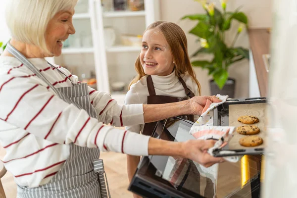 Agréable fille regardant sa grand-mère heureuse — Photo