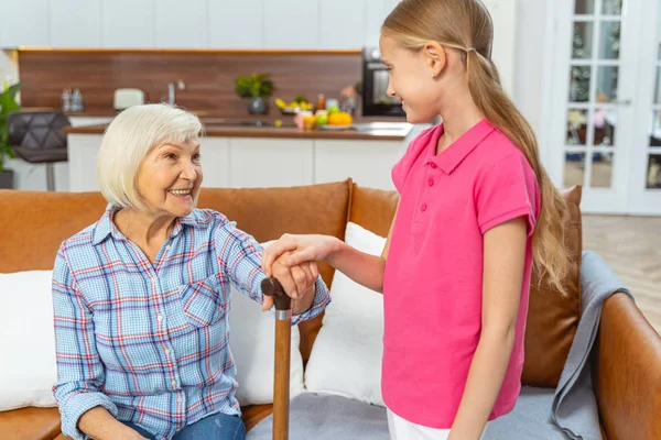 Zorgvuldig jong meisje aanraken haar grootmoeder hand — Stockfoto