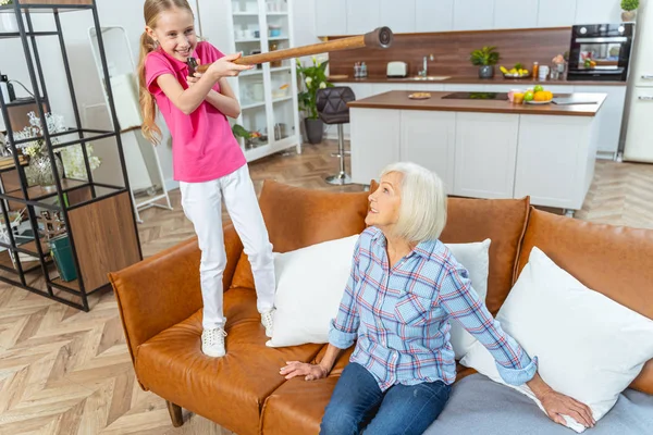 Schelmisches Enkelkind unterhält Großeltern auf dem Sofa — Stockfoto