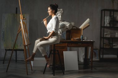 Çalışırken gülümseyen genç kadın sanatçı