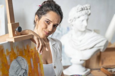 Mutlu kadın sanatçı anıtın yanında poz veriyor.