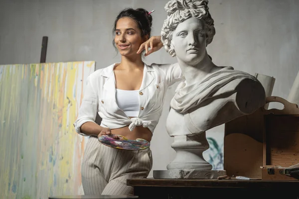 Charming female artist is posing near monument — Stock Photo, Image