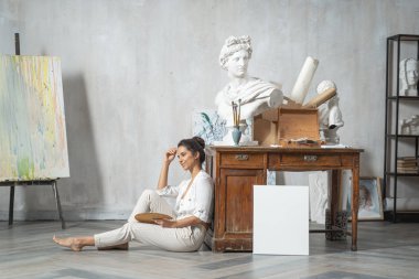 Çalışkan beyaz kadın sanat odasında yeni bir tablo çizmek için toplanıyor.