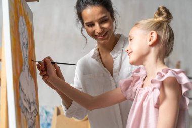 Resim dersinde resim çizen sevimli küçük kız.