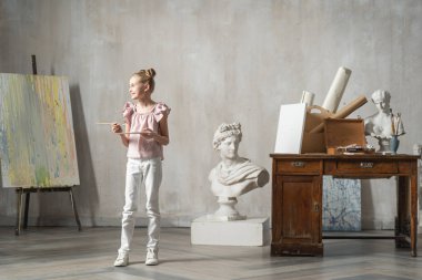 Küçük beyaz çocuk elinde renk paleti tutuyor.