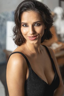 Kameraya içeride poz veren beyaz tenli çekici kadın.