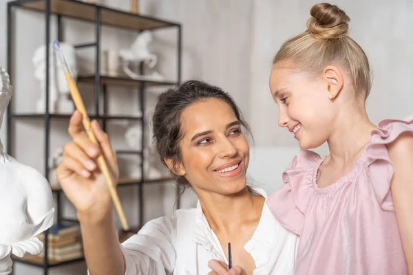 Sonriente madre pasando tiempo con su hija en el estudio de arte —  Fotos de Stock