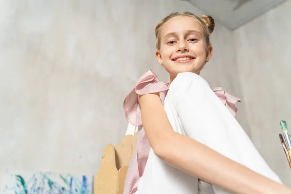 Кавказская веселая маленькая девочка позирует перед камерой в помещении — стоковое фото