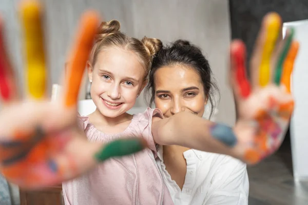Trevlig söt flicka visar målade färgade handflator till kamera — Stockfoto