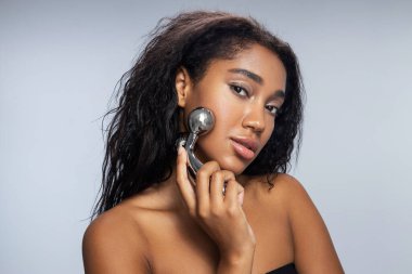 Stüdyoda yüz masajı yapan hoş ve çekici bir bayan.