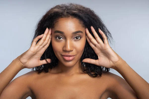 Hermosa mujer afroamericana tocándose la cara en el estudio — Foto de Stock