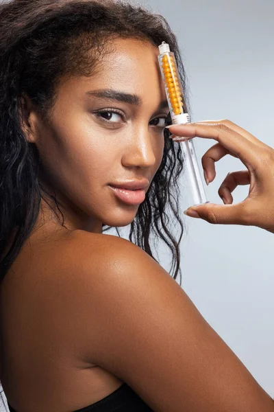 Affascinante donna afro americana con i capelli ricci mantenendo la siringa in mano — Foto Stock