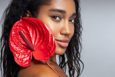 Kameraya poz veren kıvırcık saçlı harika bir kadın.