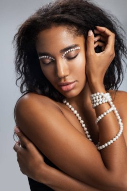 Makyajlı, kameraya poz veren hoş bir kadın.