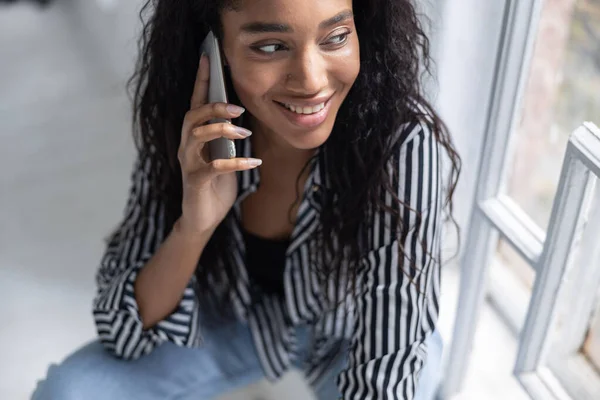 Carino afro americano signora in camicia a righe avendo riposo a casa — Foto Stock