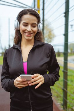 Güzel, uzun saçlı esmer, aletinin ekranına bakıyor.