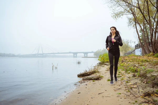 Активная молодая женщина бежит вдоль берега — стоковое фото
