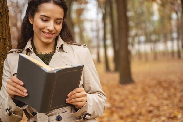Fille brune joyeuse lisant son livre préféré — Photo