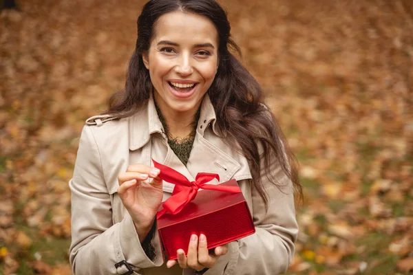 Joyful longhaired mulher pessoa demonstrando seu presente — Fotografia de Stock