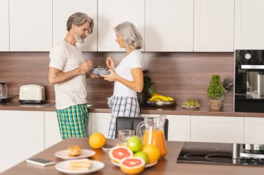 Bir kadın ve bir erkek birlikte kahvaltı yapıyor.