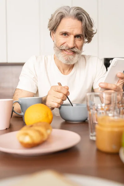 Mature man eating muesli in the morning — Stock Photo, Image