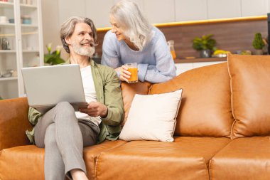 Kadın kanepenin üzerinde kocasına doğru eğiliyor.