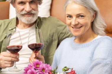 Kocasının yanında oturan gülümseyen kadın.