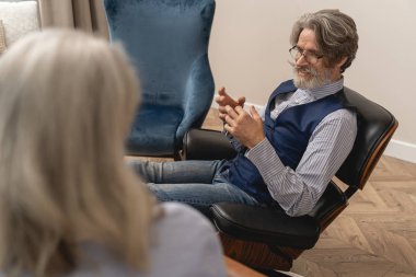 Yakışıklı iş adamı, kadın psikoloğuna gülümsüyor.