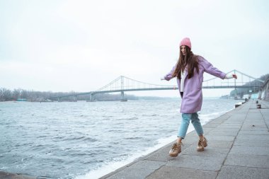 Nehir kıyısında yürüyen çekici, uzun saçlı bir kadın.