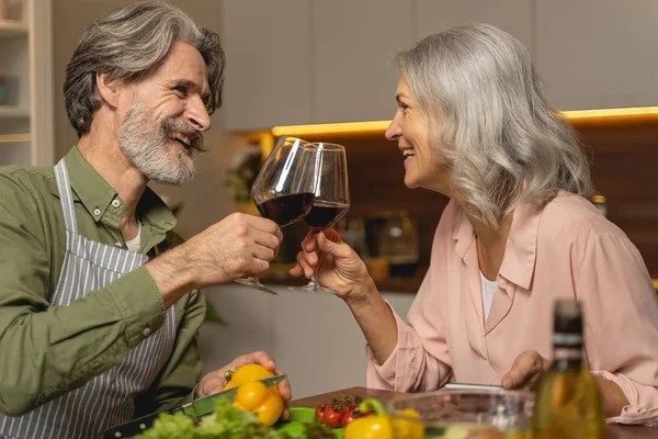 Coppia sposata che beve vino rosso in cucina — Foto Stock