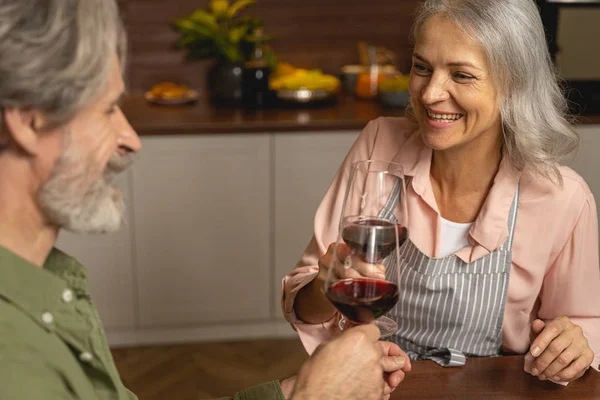 Fröhliche Hausfrau mittleren Alters genießt die Gesellschaft ihrer Ehemänner — Stockfoto