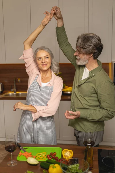 Ehemann wirbelt seine zufriedene Frau beim Tanz auf — Stockfoto