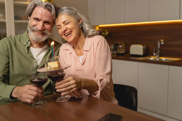 Lachende Menschen heben ihre Gläser am Tisch — Stockfoto