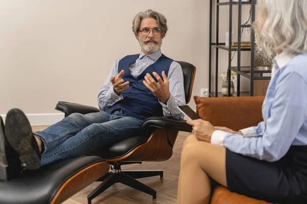 Беспокойный мужчина средних лет разговаривает со своим психотерапевтом — стоковое фото