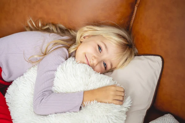 Entzückendes kleines Mädchen, das zu Hause auf der Couch liegt — Stockfoto