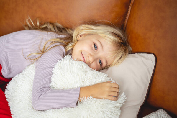 Adorable little girl lying on couch at home
