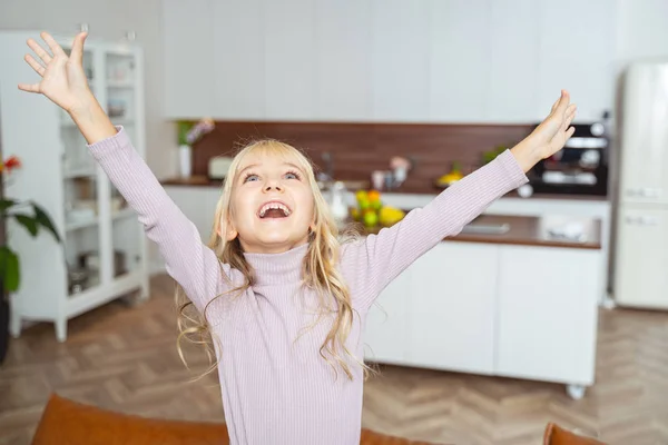 Allegro bambina alzando le mani e guardando in alto — Foto Stock