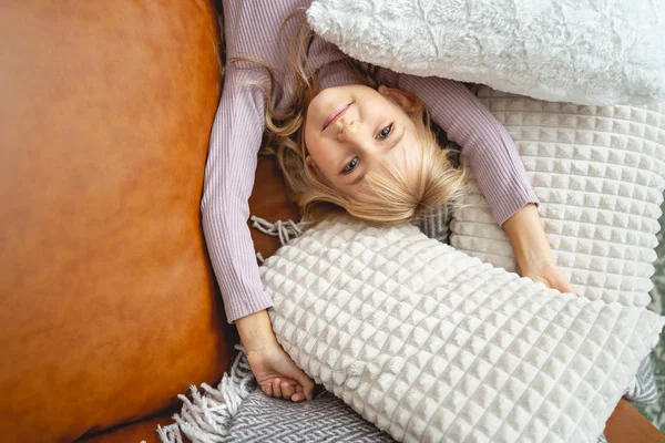 Bambino carino che riposa sul divano con cuscini — Foto Stock