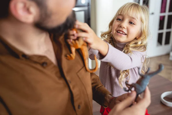 Linda niña poniendo dinosaurio de juguete en el hombro de papá —  Fotos de Stock