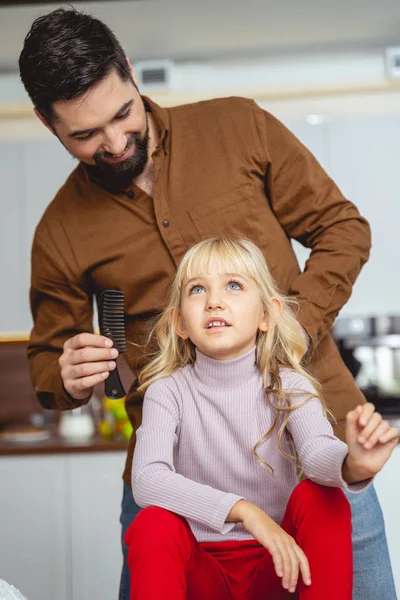 Vidám apa fésüli a lánya haját. — Stock Fotó